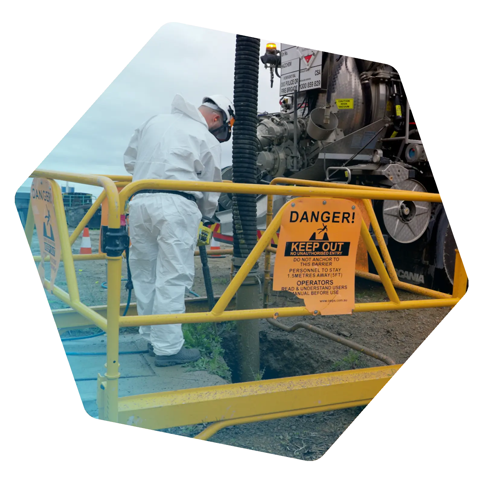 Vacuum loading underway beside an industrial vacuum truck within a restricted work area