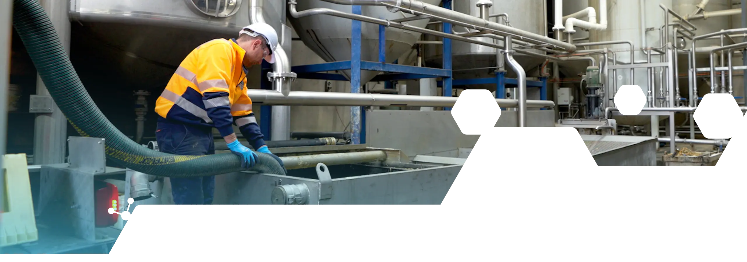 Vacuum hose being used for liquid and sludge recovery within an industrial processing area