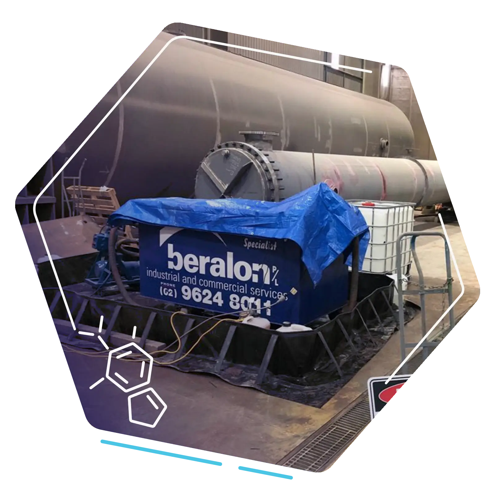 Beralon cleaning equipment positioned beside a large industrial heat exchanger inside a workshop