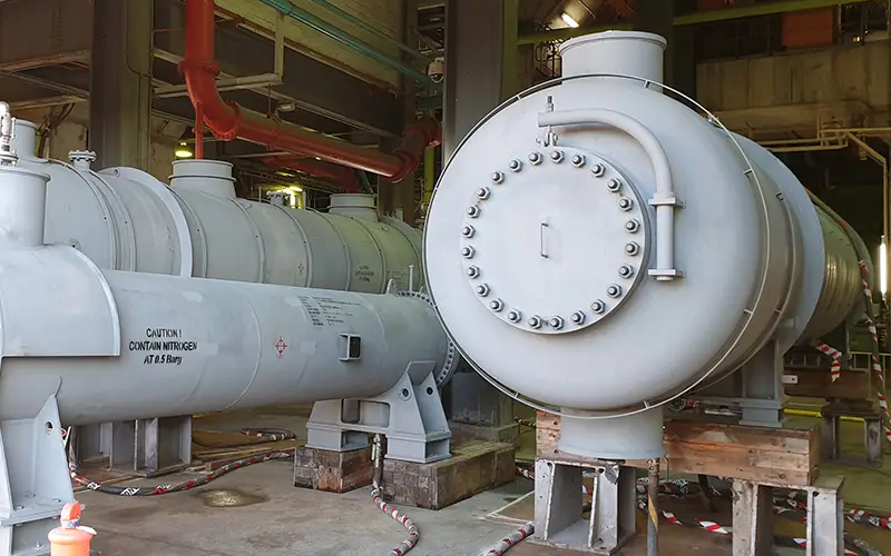 Large shell-and-tube heat exchangers installed inside an industrial facility