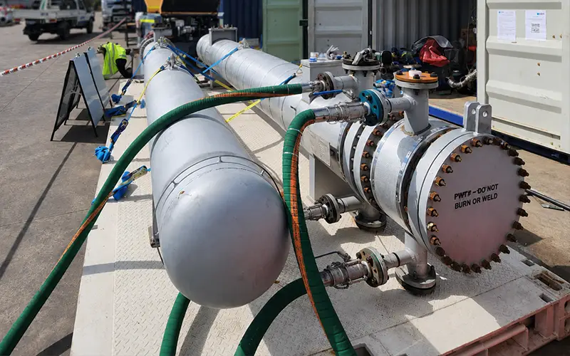 Industrial heat exchanger connected to hoses and circulation equipment during onsite cleaning