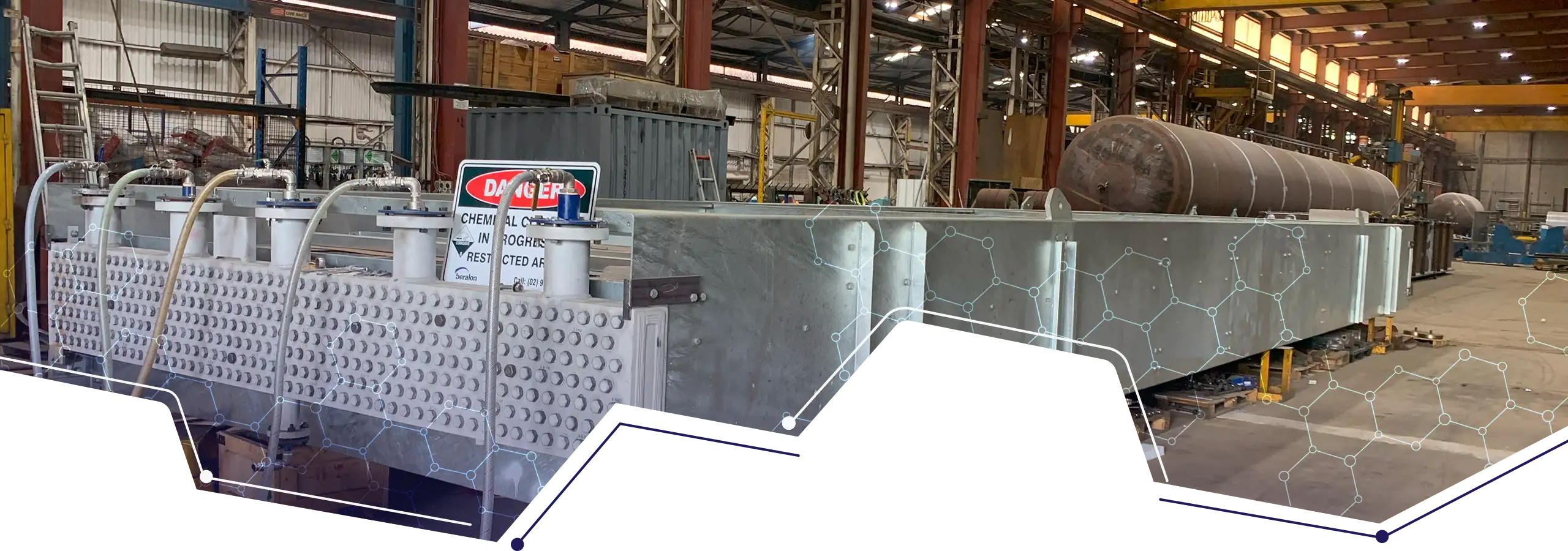 Large industrial heat exchanger with exposed tube sheet inside a workshop