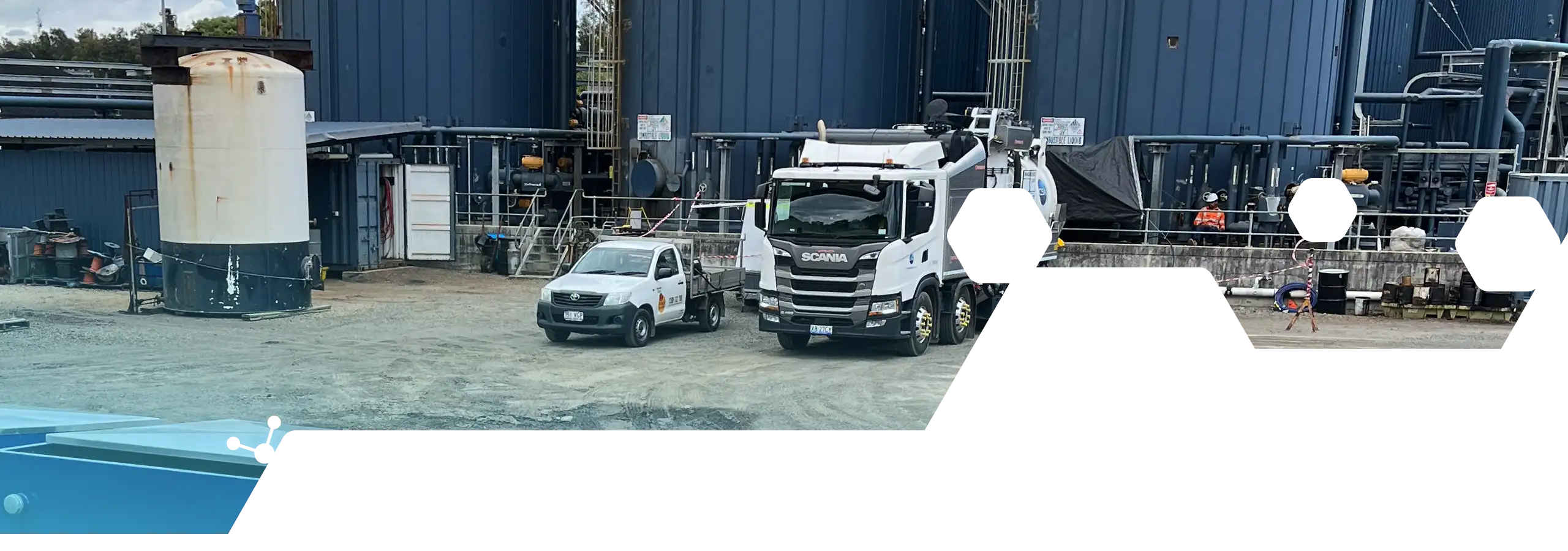 Industrial facility with vacuum truck, storage tank and extensive process pipework